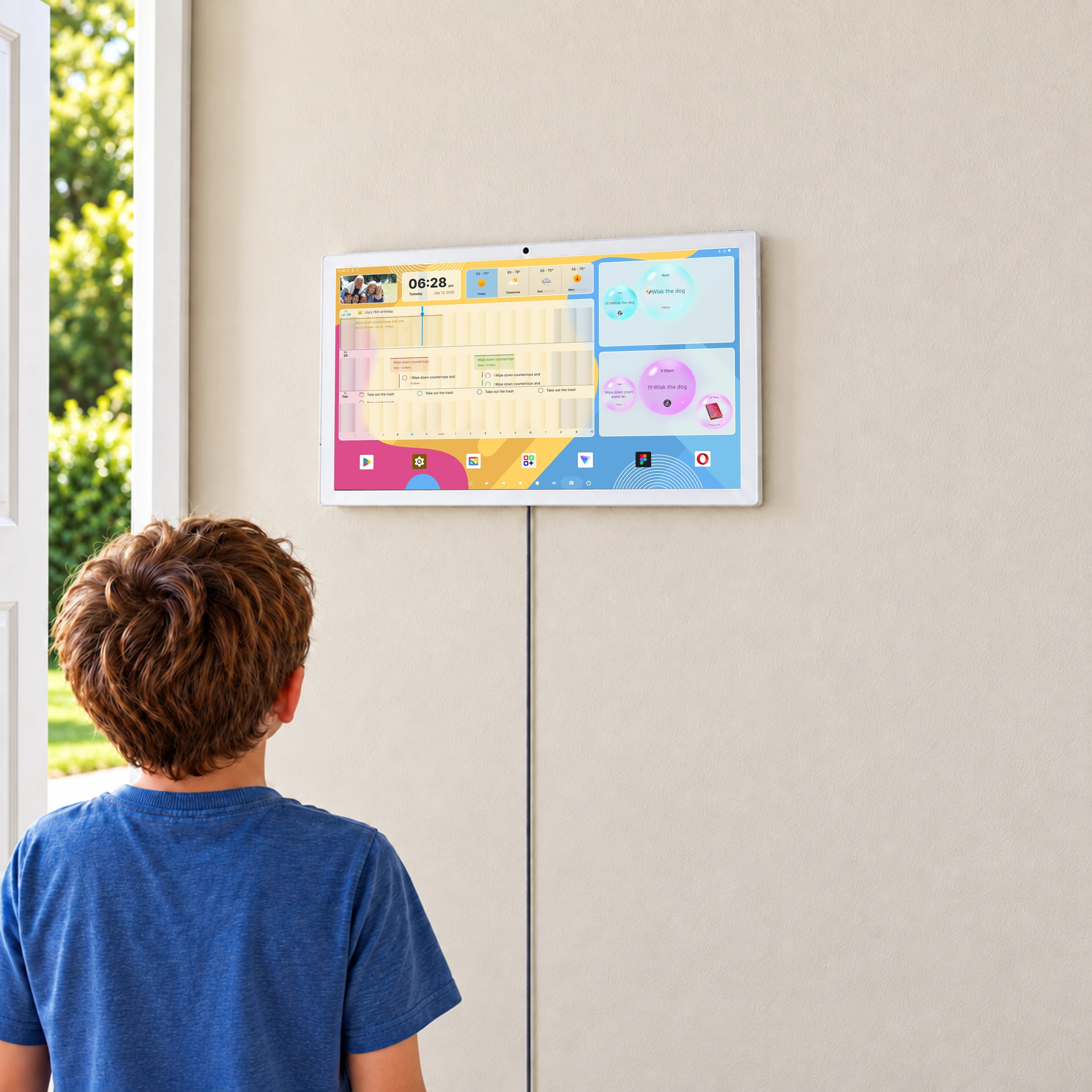 A child looking at the family calendar on Odic Board beside an open doorway to the garden